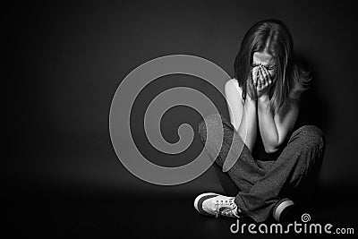 Woman in depression and despair crying on black dark Stock Photo