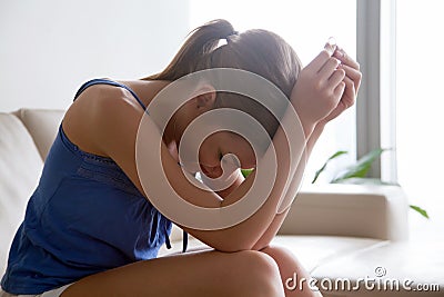 Woman in despair through divorce sitting with ring Stock Photo