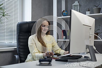 Woman director sits in leather armchair in office and reads documents. Boss checks contract Stock Photo
