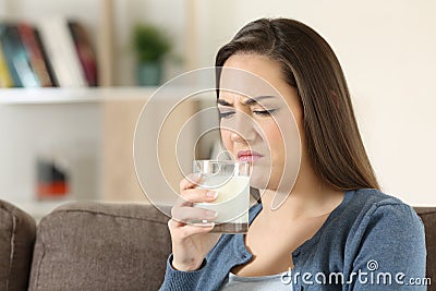 Woman disgusted tasing milk with bad flavor Stock Photo