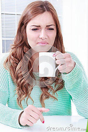 Woman disgusting smell of coffee with face expression Stock Photo