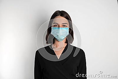 Woman with disposable mask on face against background Stock Photo