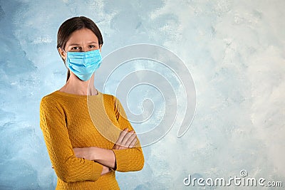 Woman with disposable mask on face against blue background. Space for text Stock Photo