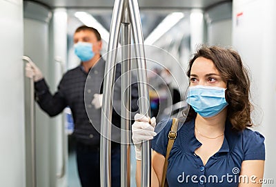 Woman in disposable mask in subway train Stock Photo