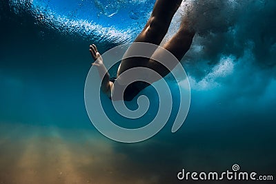 Woman dive without surfboard under wave. Underwater duck dive under wave and sandy bottom Stock Photo