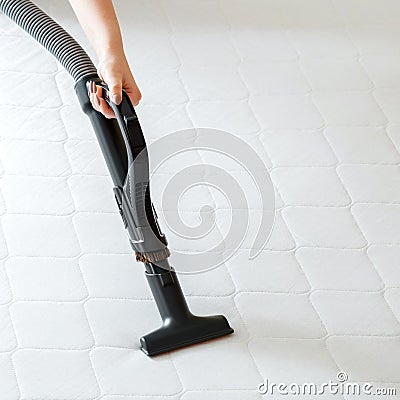 Woman do Professional cleaning mattress by vacuum cleaner from dust bacteria dirty. Vacuum cleaner machine in female Stock Photo