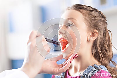 Woman doctor checking throat of little girl Stock Photo