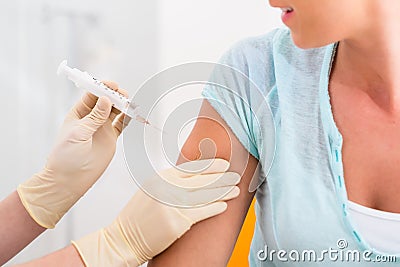 Woman at doctor getting vaccination syringe Stock Photo