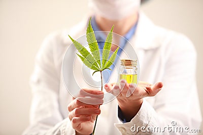 Woman doctor holding a cannabis leaf and oil.alternative medicine Stock Photo