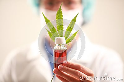 Woman doctor holding a cannabis leaf and oil.alternative medicine Stock Photo