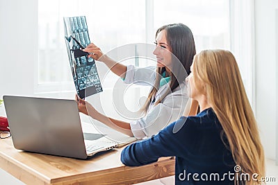 Woman doctor and patient looking at the x-ray or Stock Photo