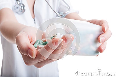 Woman doctor pouring pills on hand Stock Photo