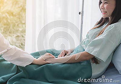 Women doctor reassuring her female asian patient in hospital room,Dentist giving a consultation and encouragement to patient toget Stock Photo