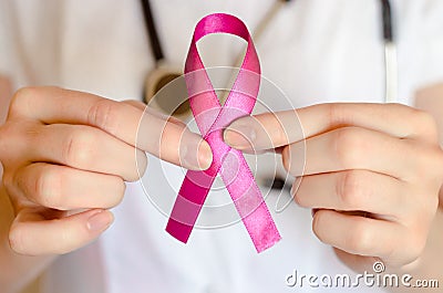Woman doctor keeps a pink ribbon close up. Breast cancer examination concept Stock Photo