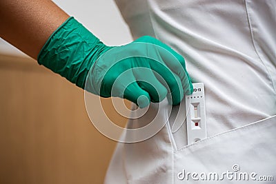 Woman doctor taking out Covid-19 rapid test from a coat Editorial Stock Photo