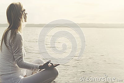 Woman does yoga in front of an ocean view Stock Photo