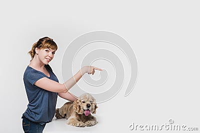 Woman with dog pointing to space at right Stock Photo