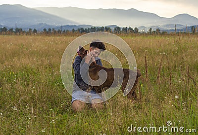 Woman with a dog walk on meadow Stock Photo
