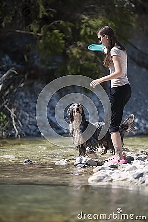 Woman and dog walking in water Stock Photo