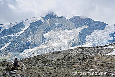 Woman and dogs sitting at path to Grossglockner Mountain and Pa Editorial Stock Photo