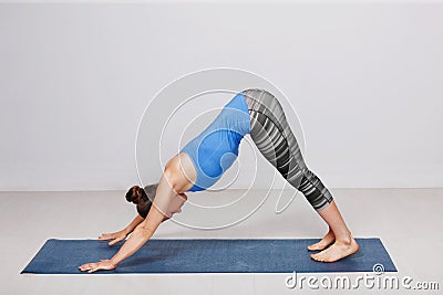 Woman doing Ashtanga Vinyasa yoga asana Adhomukha svanasana Stock Photo