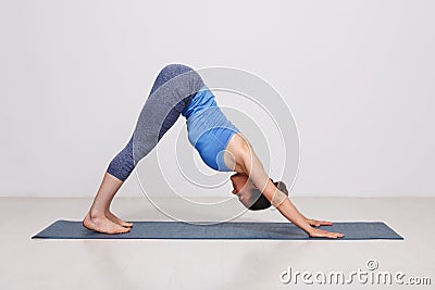 Woman doing Ashtanga Vinyasa yoga asana Adhomukha svanasana Stock Photo