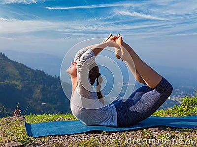 Woman doing Ashtanga Vinyasa Yoga asana Dhanurasana - bow pose Stock Photo