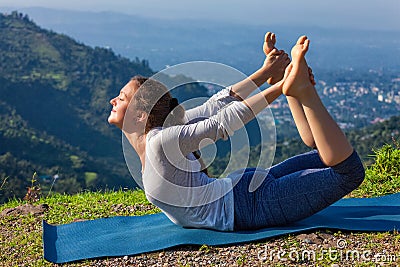 Woman doing Ashtanga Vinyasa Yoga asana Dhanurasana - bow pose Stock Photo