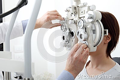 Woman doing eyesight measurement with optical phoropter Stock Photo