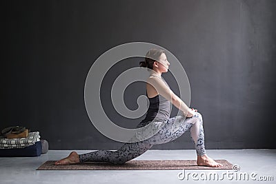 Woman doing Hatha yoga asana Anjaneyasana or low crescent lunge pose isolated, Stock Photo