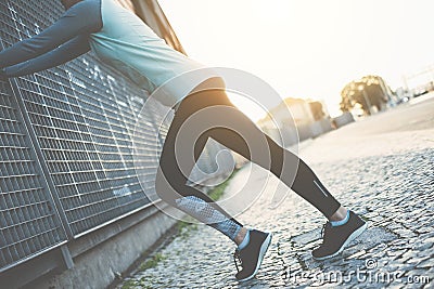 Sporty woman doing legs warming exercise, safety stretching before running Stock Photo