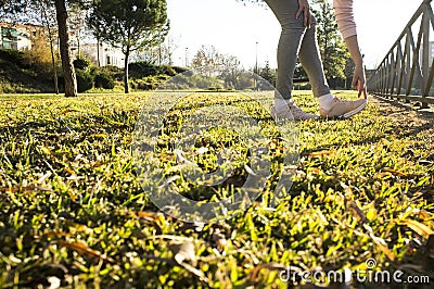 Woman doing stretching exercises at urban park in autumn season Stock Photo