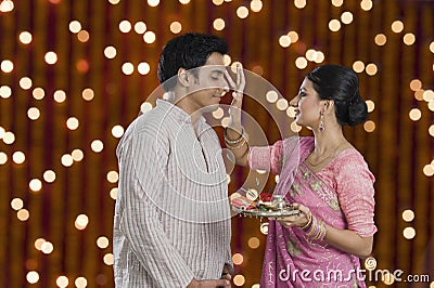 Woman doing tilak of her husband on Diwali Stock Photo