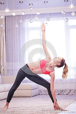 Woman doing triangle yoga pose Stock Photo