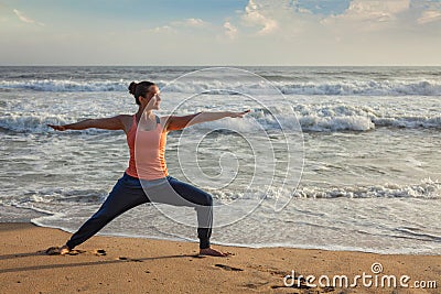 Woman doing yoga asana Virabhadrasana 1 Warrior Pose on beach on Stock Photo