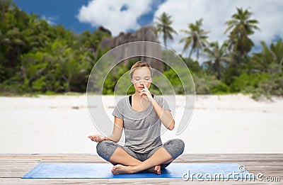 Woman doing yoga breathing exercise on beach Stock Photo