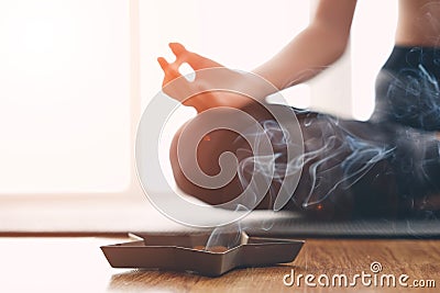 Woman doing yoga and burning scented sticks Stock Photo