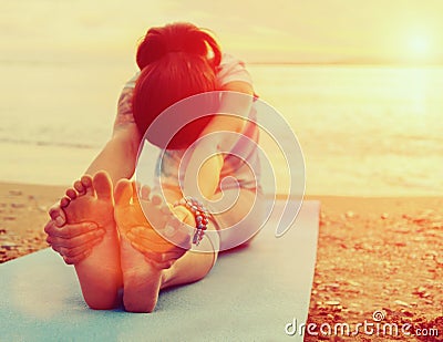 Woman doing yoga exercise on beach Stock Photo