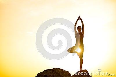 Woman Doing Yoga Outdoor. Warm up Exercise Against Sunset. Sport and Healthy Active Lifesyle Concept. Stock Photo