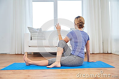 Woman doing yoga twist exercise at home Stock Photo