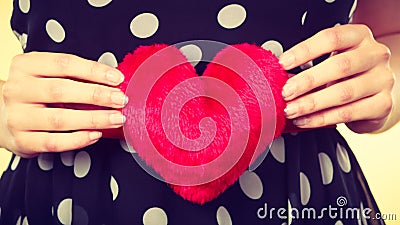 Woman in dotted dress holding red heart Stock Photo