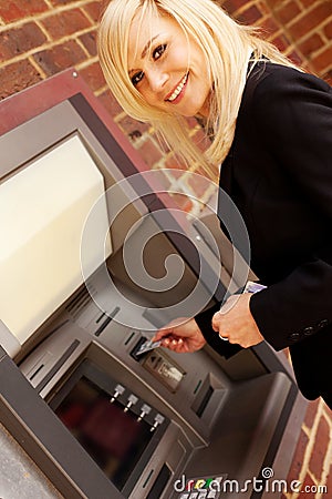 Woman drawing cash at an ATM Stock Photo