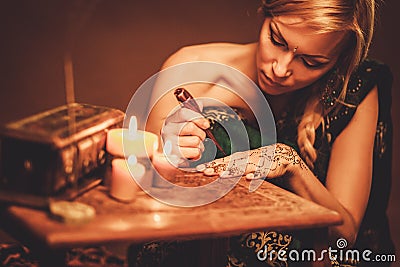 Woman drawing henna menhdi ornament Stock Photo