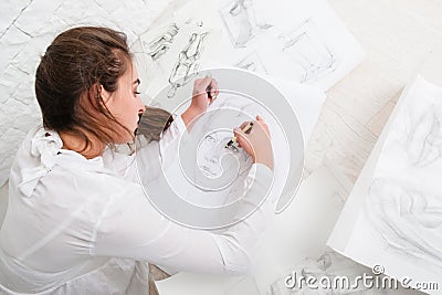 Woman drawing pencil portrait on floor in workshop Stock Photo