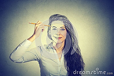 Woman drawing self portrait with pencil Stock Photo