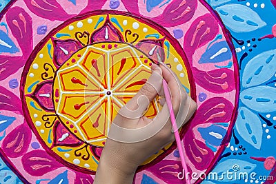 Woman draws a mandala, hand with a brush close-up Stock Photo