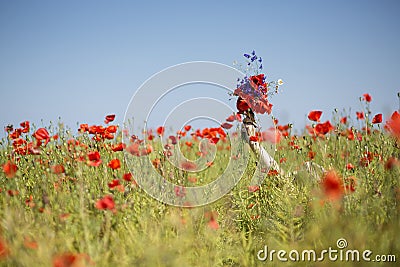 Woman at dress drowns in poppy field Stock Photo