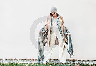 Woman dressed in multilayered autumn outfit: camel coat, denim j Stock Photo