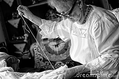 A woman sews traditional tablecloths Editorial Stock Photo