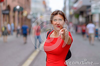Woman dressed in red dress pointing at camera Stock Photo